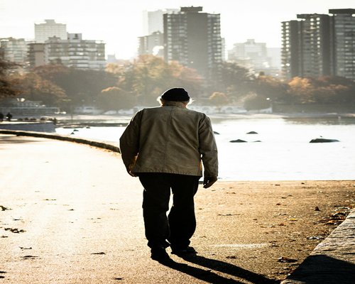 Person taking a calm walk in an urban park, avoiding city stress